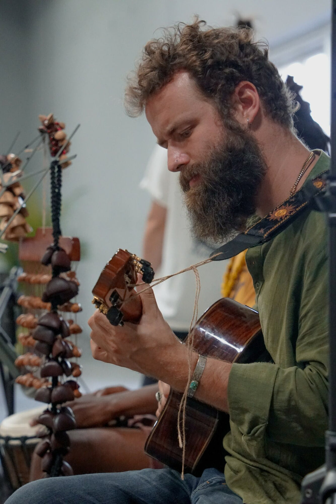 Clinton Greenlee tocando una guitarra acústica durante una sesión de música en vivo